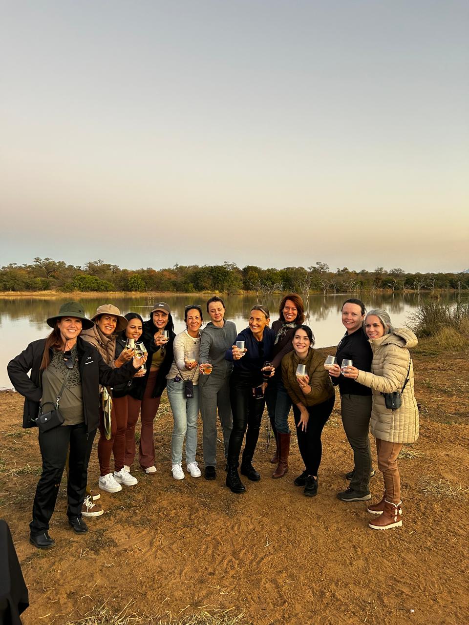 Grupo Elas pelo Mundo reunido para o sundowner à beira do lago