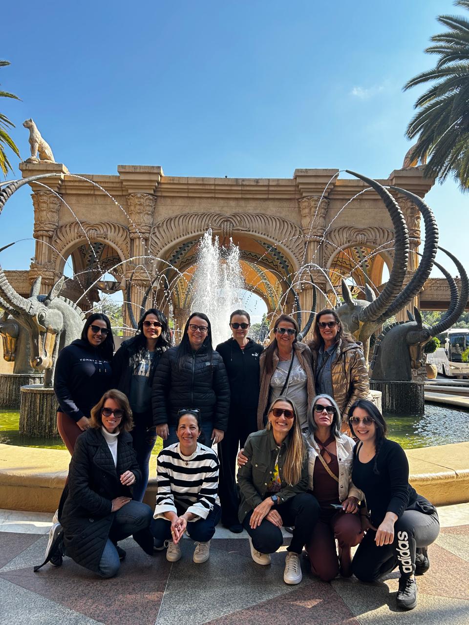 Grupo Elas pelo Mundo diante da fonte em Sun City